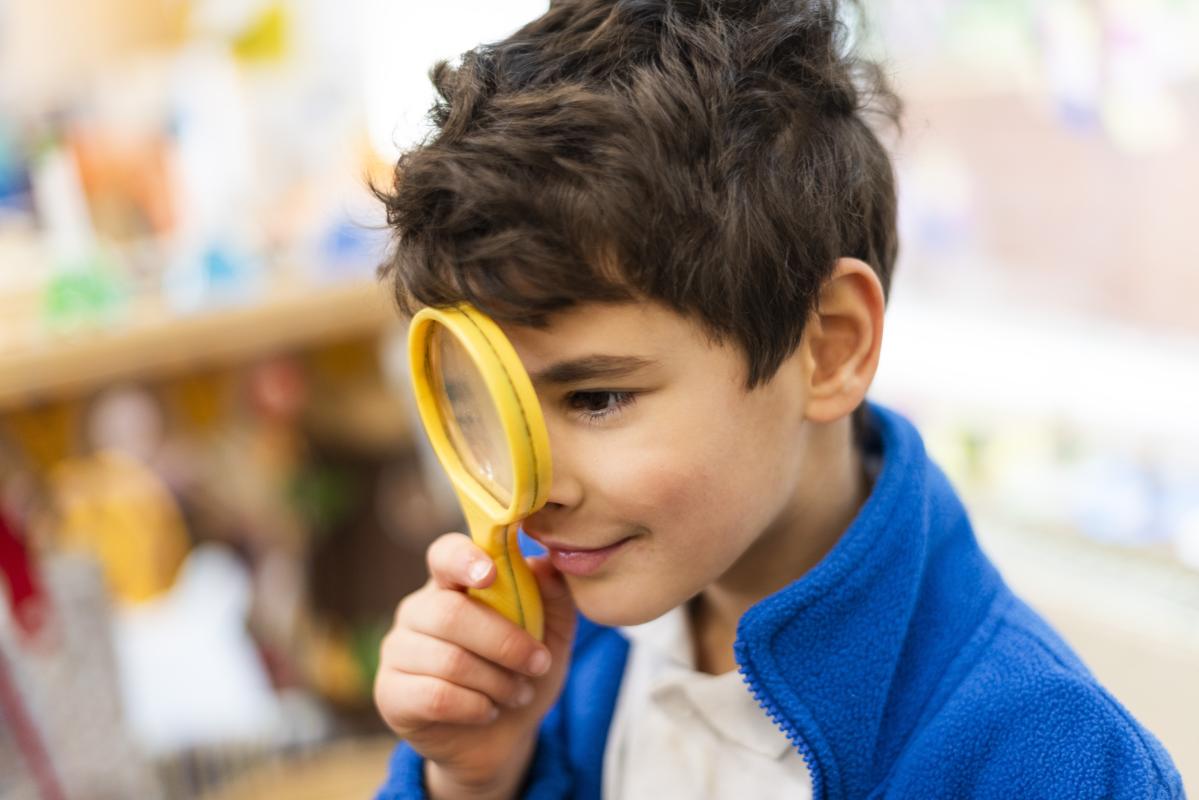 A Stedham pupil exploring through a yellow magnifying glass